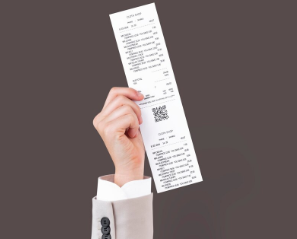 A imagem mostra uma mão segurando uma nota fiscal eletrônica
