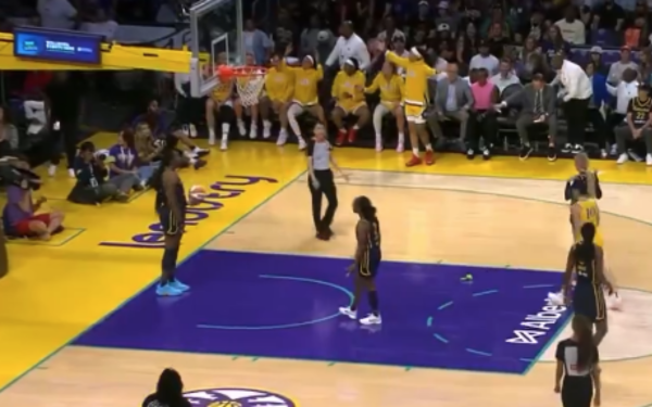 Imagem de uma partida de basquete feminino da WNBA. O momento mostra jogadoras posicionadas na área do garrafão, aguardando a cobrança de lance livre. O banco de reservas ao fundo tem atletas e comissão técnica da equipe de uniforme amarelo. Um detalhe inusitado chama atenção: um brinquedo íntimo, está caído na quadra próximo à linha do lance livre.